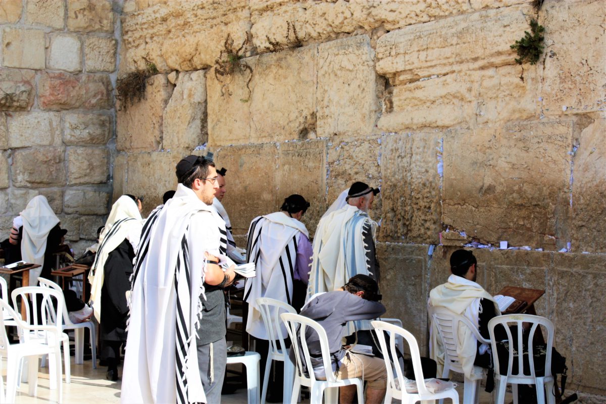 Religijni Żydzi wznoszący modlitwy pod Ścianą Płaczu w sektorze przeznaczonym wyłącznie dla mężczyzn. W tle karteczki z modlitwami